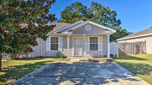 A single-story house with a front porch, a small front yard, and a wooden fence. - Cute Pensacola Townhome ~ 9 Mi to Downtown! (Pensacola)