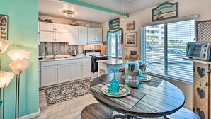 A kitchen with white cabinets, a wooden island, and a dining area with a round table. - Daytona Beach Retreat w/ Views & Pool Access! (Daytona Beach)