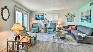 A living room with a large window, two armchairs, a sofa, a coffee table, and a lamp. - Daytona Beach Retreat w/ Views & Pool Access! (Daytona Beach)