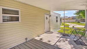 A covered porch with a sliding glass door, a small table, and a chair. - Daytona Beach Home ~ 4 Mi to Daytona Speedway (Daytona Beach)