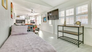 A spacious room with a bed, a desk, and a TV on the wall. - 'driftwood Beach Suite' - Walk to Clearwater Bch (Clearwater Beach)