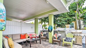 An outdoor patio area with a covered seating area, a grill, and a dining table. - 'driftwood Beach Suite' - Walk to Clearwater Bch (Clearwater Beach)