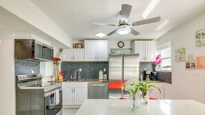 A modern kitchen with stainless steel appliances, white cabinetry, and a central island. - 'driftwood Beach Suite' - Walk to Clearwater Bch (Clearwater Beach)