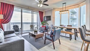A modern living room with a sofa, coffee table, and dining area. - Family Resort Condo w/ 2 Pools: 1 Mi to Disney! (Orlando)