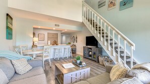 A spacious living area with a sofa, a coffee table, and a staircase.