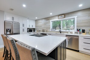 A modern kitchen with white cabinetry, stainless steel appliances, and a large island. - Inverness Getaway ~ 4 Mi to Henderson Lake! (Inverness)
