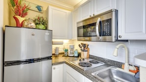 A modern kitchen with stainless steel appliances, white cabinetry, and a granite countertop. - Daytona Beach Studio w/ Private Lanai 1 Mi to Pier (Daytona Beach)