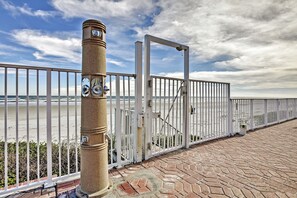 A coastal walkway with a metal fence, a gate, and a stone pillar. - Daytona Beach Studio w/ Private Lanai 1 Mi to Pier (Daytona Beach)