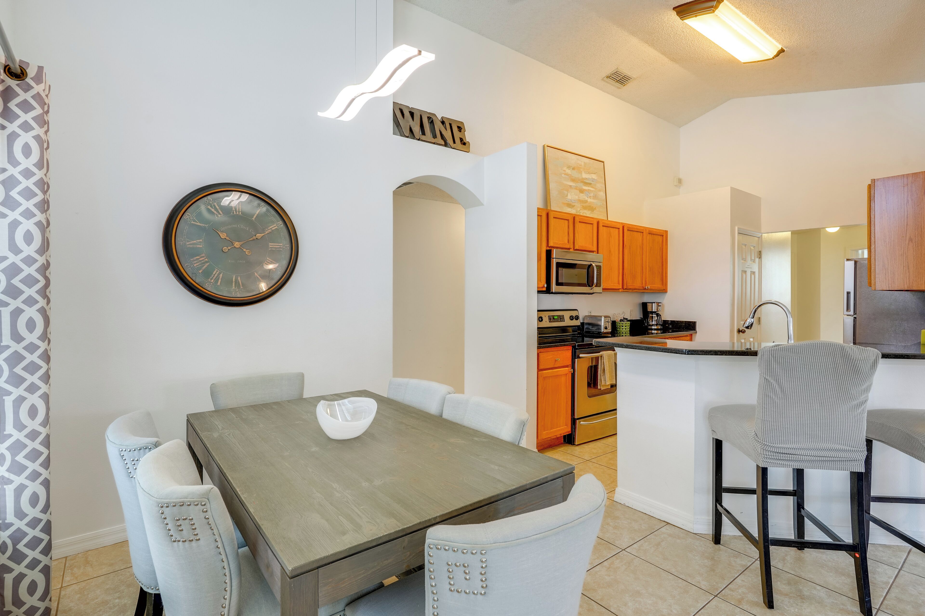 A modern kitchen with wooden cabinets, a microwave, and an oven.