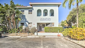 A two-story building with a sign reading "Sandy by The Sea". - Idyllic Apt w/ Pool Access - Walk to Beach! (Lauderdale-by-the-Sea)