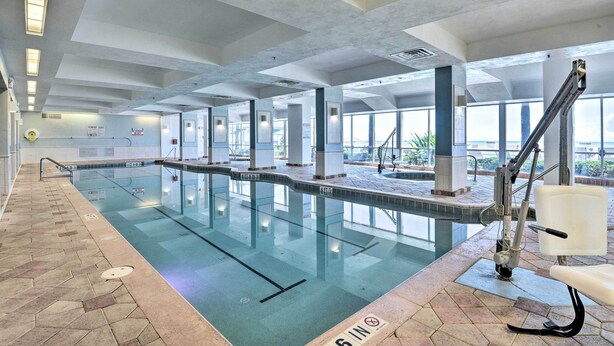 An indoor swimming pool with clear lane markings, a lifeguard chair, and a tiled floor with a 3 ft 6 in depth marker.