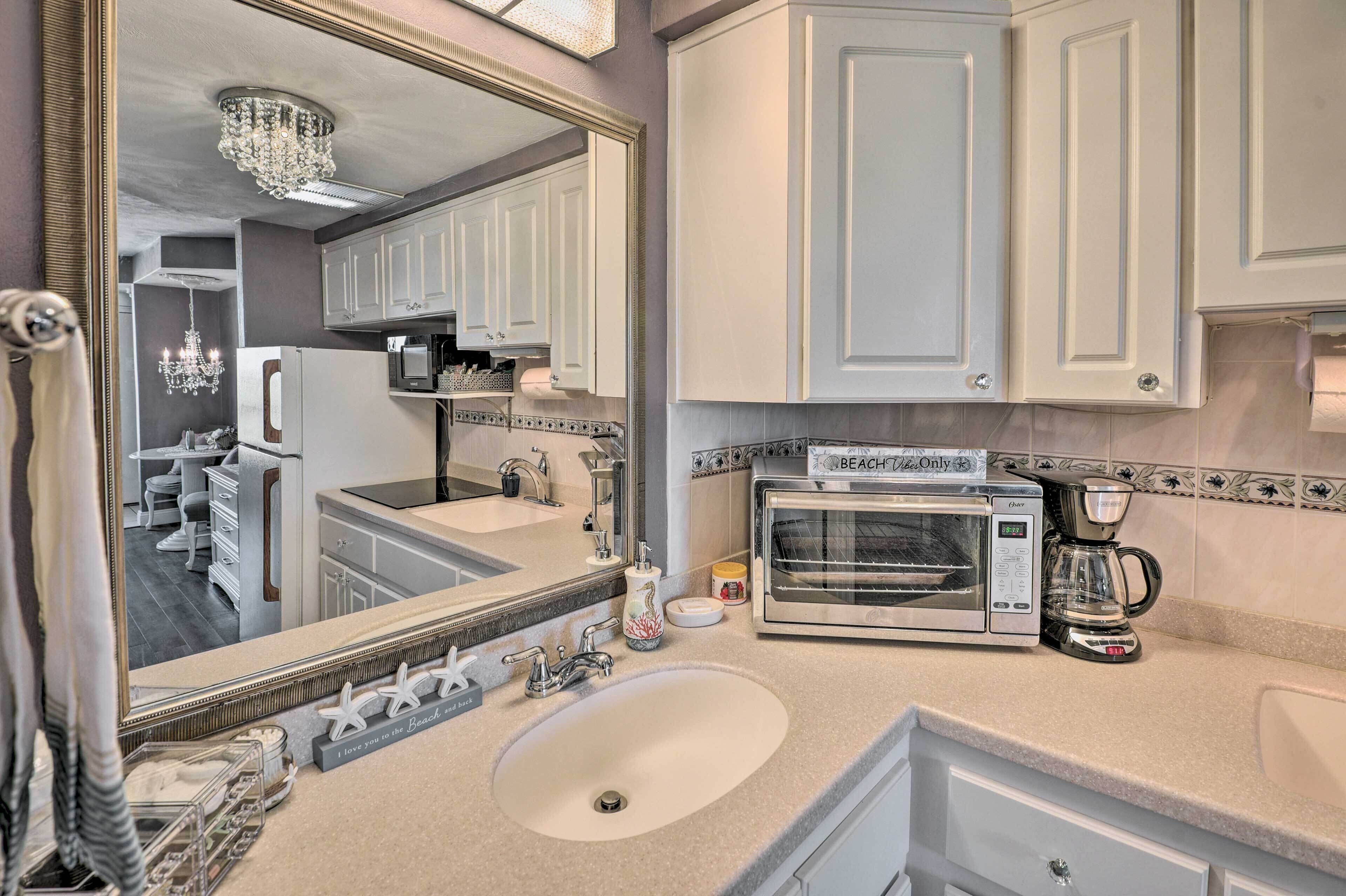 A modern kitchen with a double sink, a built-in oven, and a coffee maker.