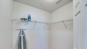 A small, clean room with a wooden floor, a metal shelf with a blue item, and a door with a brass doorknob. - Deltona Retreat w/ Yard + Grill: Pets Welcome! (Deltona)