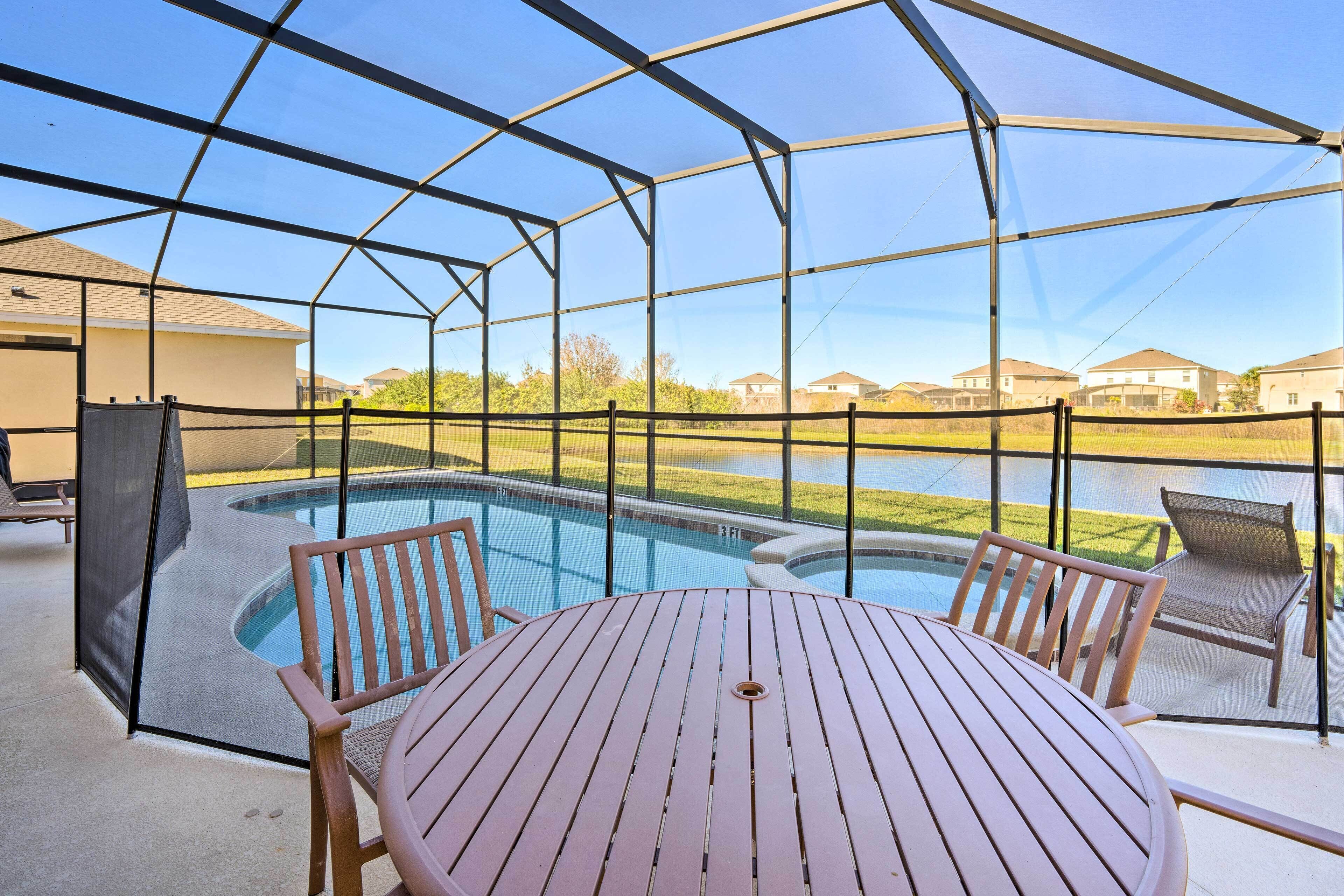 A covered outdoor area with a pool, a table, and chairs.