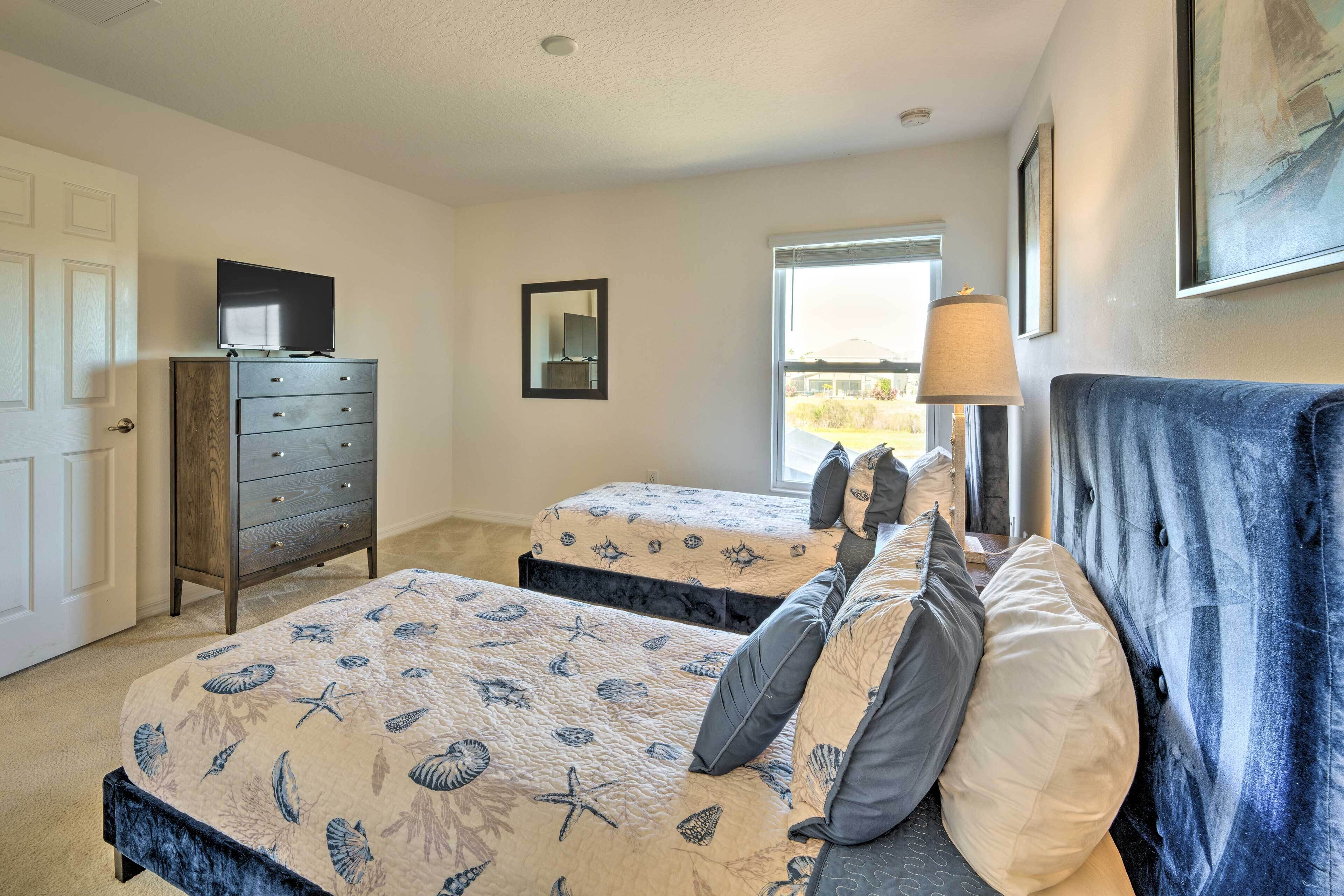 Une chambre avec deux lits, une commode, un miroir et une fenêtre donnant sur un beau paysage.