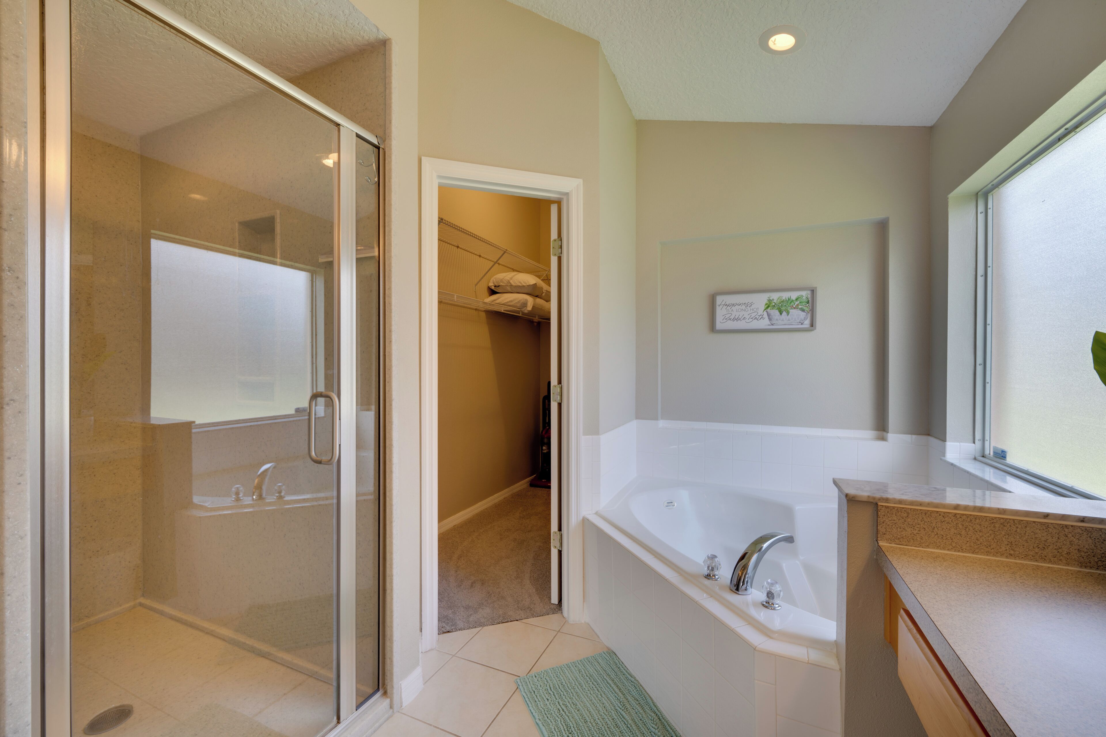 A modern bathroom with a glass shower enclosure, a walk-in bathtub, and a large mirror.