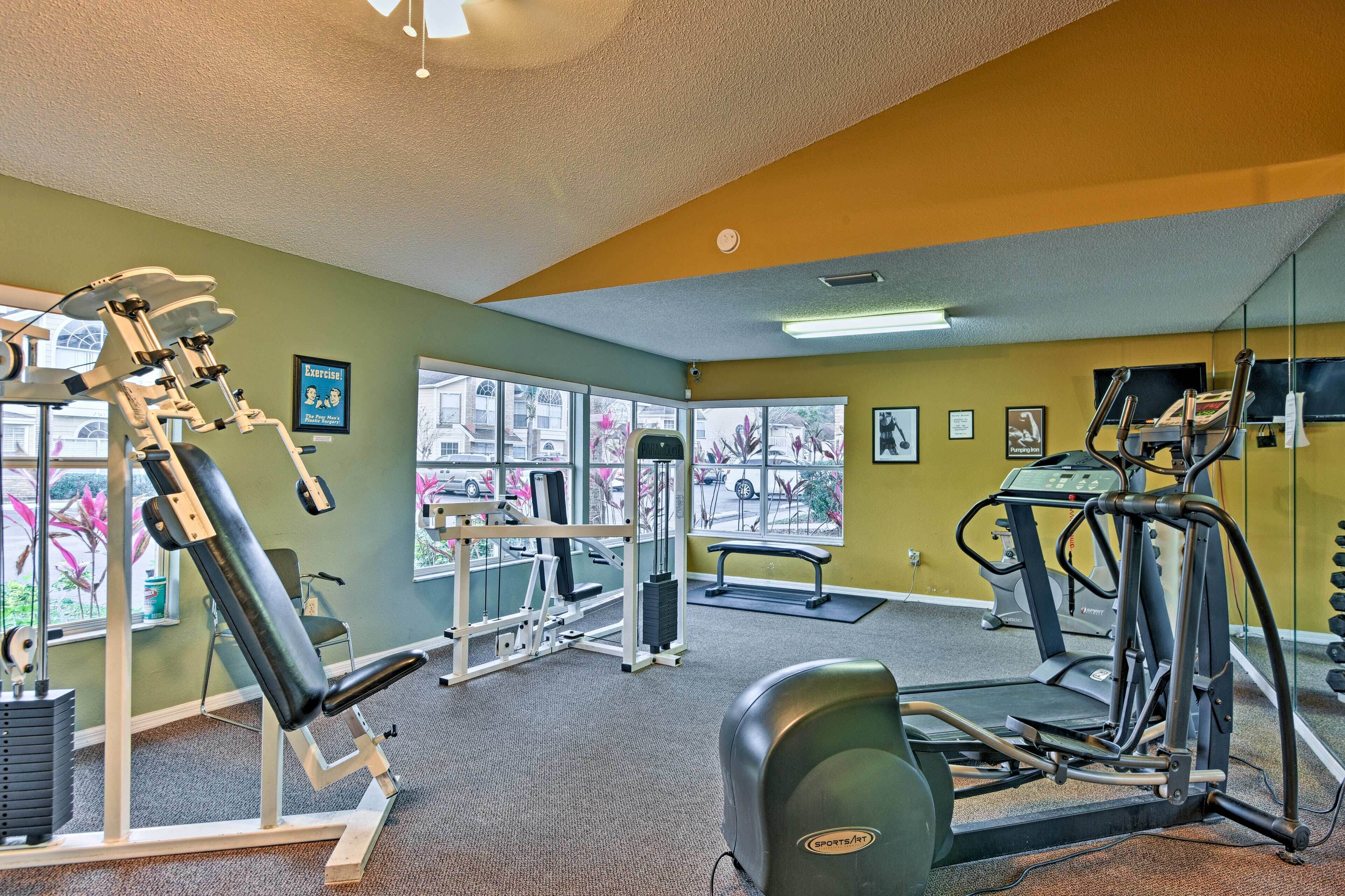 Une salle de sport équipée de matériel d’exercice, dotée de grandes fenêtres et offrant une vue sur l’extérieur.