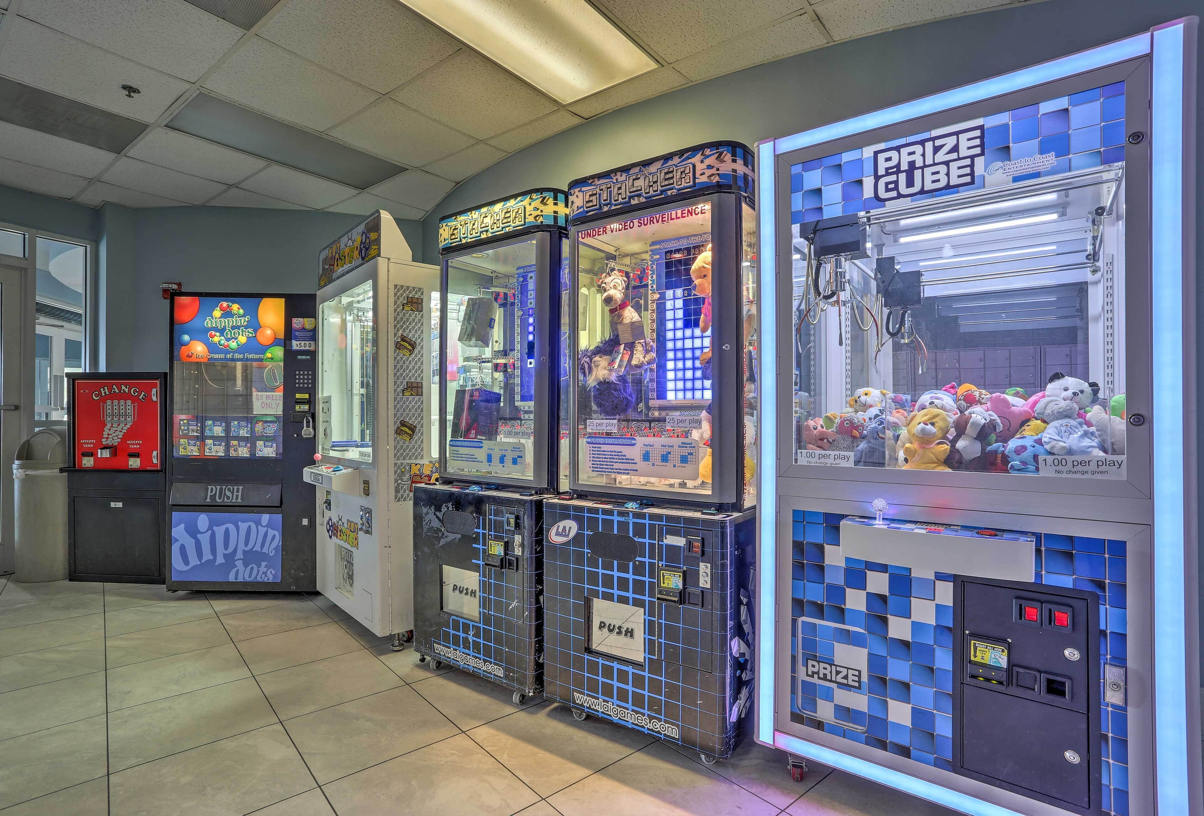 A row of arcade machines including 'Amper Dotz' and 'Prize Cube' in a public indoor space.