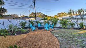 A backyard with a seating area, a fire pit, and various plants. - Lush Seminole Surf Inn w/ Backyard Fire Pit! (Seminole)