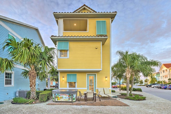 A two-story yellow building with a patio area featuring outdoor seating and a hot tub. - 3 Mi to Disney: Home w/ Hot Tub in Margaritaville! (Kissimmee)