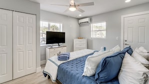 A bedroom with a bed, a television, a ceiling fan, and a window. - Walk to Gulf: Madeira Beach Condo w/ Patio (Madeira Beach)