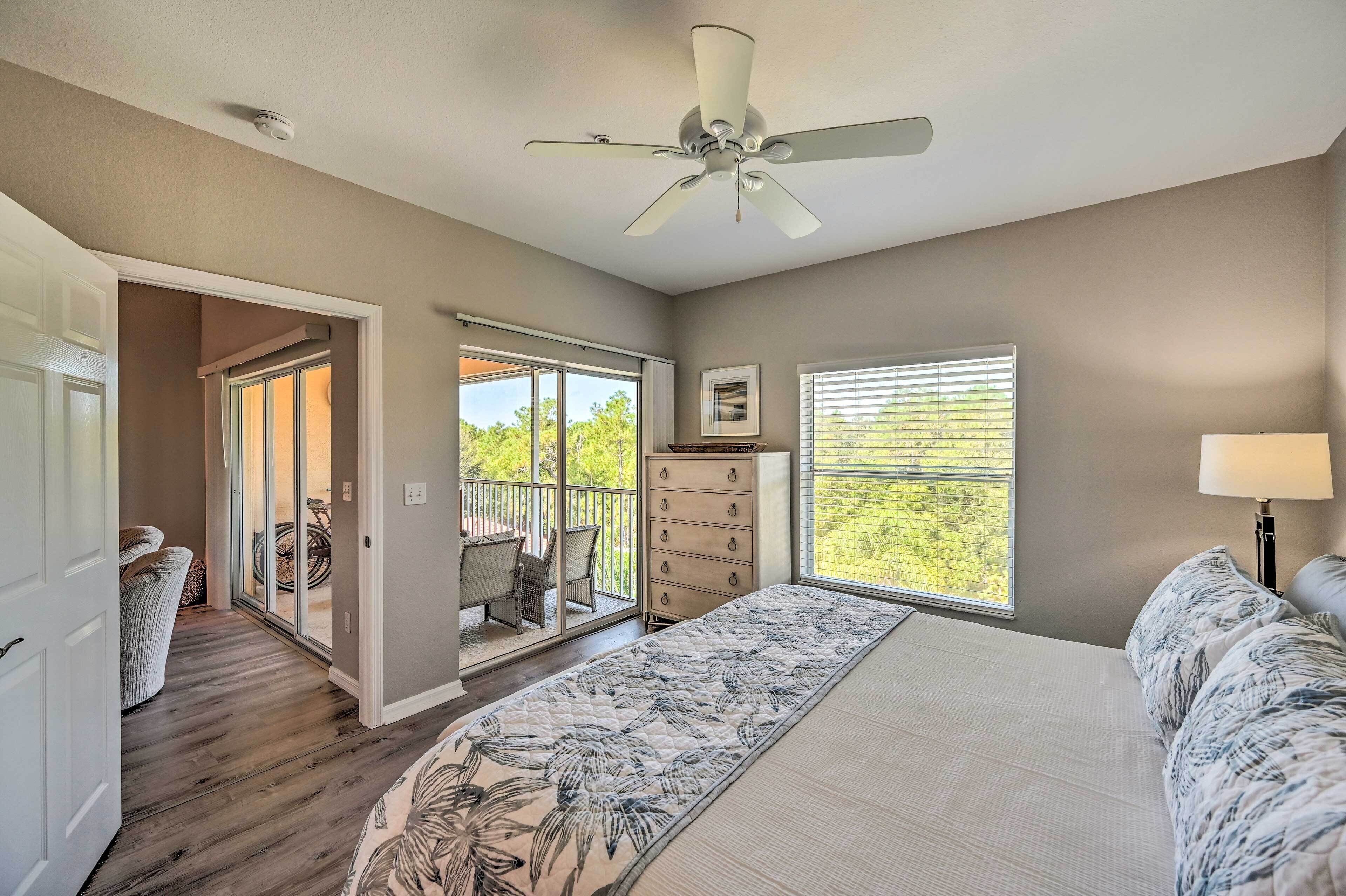 A bedroom with a bed, a ceiling fan, a dresser, and a window with blinds.