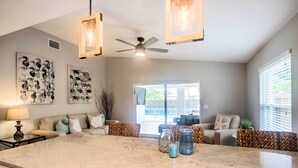 A spacious kitchen with a large island, pendant lights, and a ceiling fan. - Naples Home w/ Lanai & Pool Near Vanderbilt Beach! (Naples)