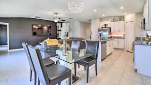 A modern kitchen with white cabinets, a stainless steel refrigerator, and a built-in oven.