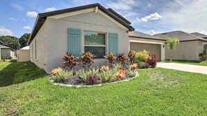 A modern single-story house with a well-maintained lawn and colorful flower beds.