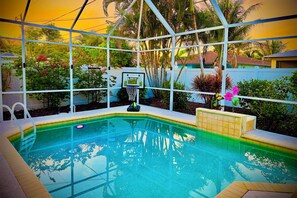 A swimming pool with a basketball hoop, surrounded by greenery and a fence. - Naples Retreat w/ Saltwater Pool: 2 Mi to Beach! (Naples)