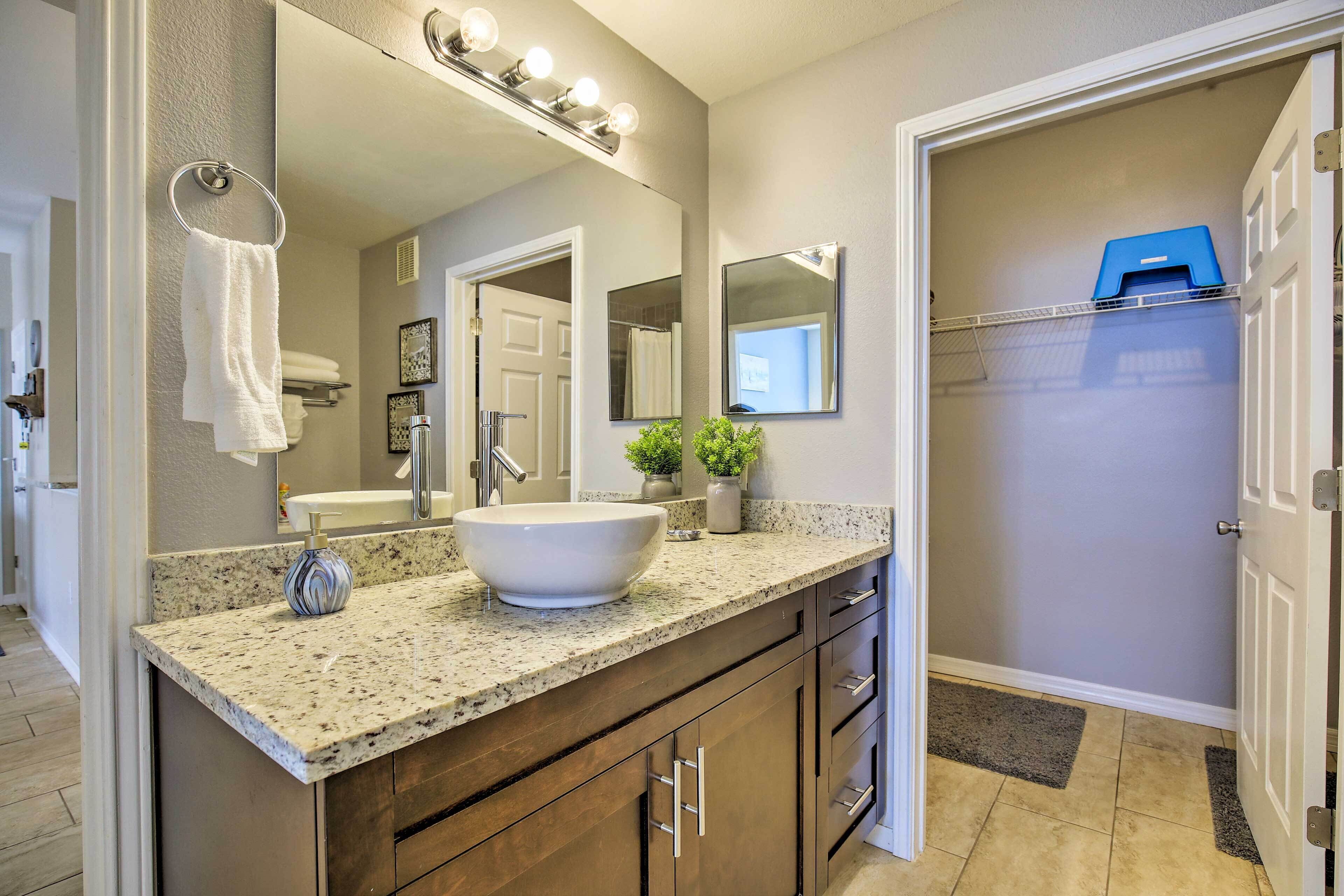 Une salle de bain avec un grand lavabo, un meuble-lavabo et un miroir.