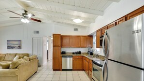 A kitchen with wooden cabinets, a stainless steel refrigerator, and a built-in dishwasher. - Ormond Beach Vacation Rental - Walk to Ocean! (Ormond Beach)