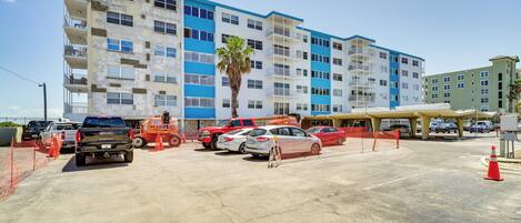 A multi-story building with a parking lot in front.