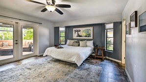 A bedroom with a bed, a ceiling fan, and a view through the glass doors. - Port Charlotte Retreat w/ Heated Pool & Spa! (Port Charlotte)