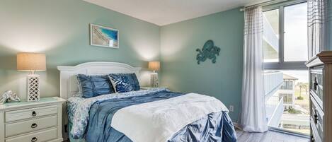A bedroom with a bed, two bedside tables, a window with curtains, and a view of the outside.
