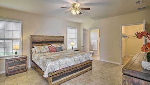 A bedroom with a wooden bed, a ceiling fan, and a nightstand with a lamp. - Sebring Gem: Close to Golf & Raceway (Sebring)