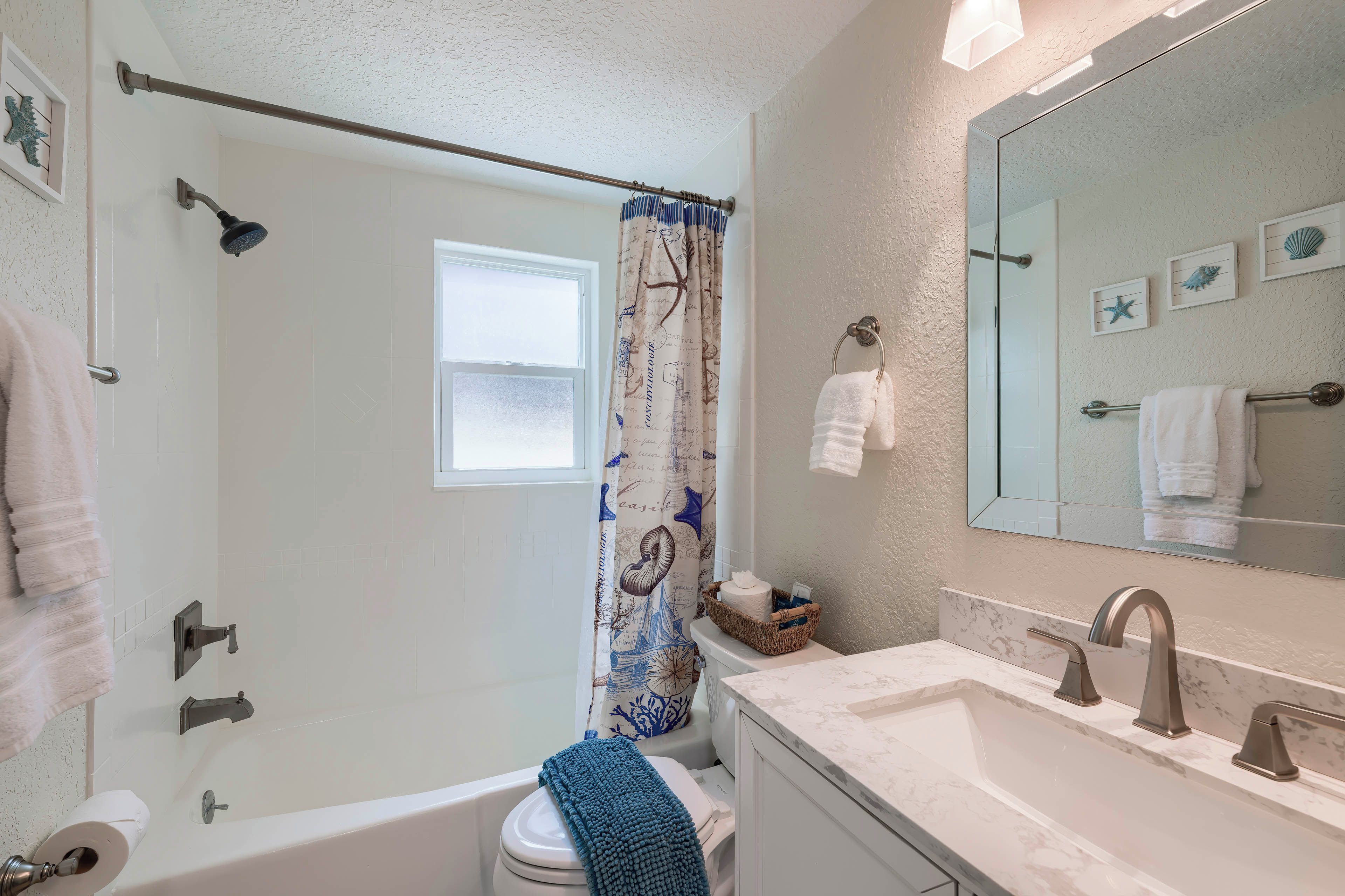 A bathroom with a bathtub, toilet, and sink.