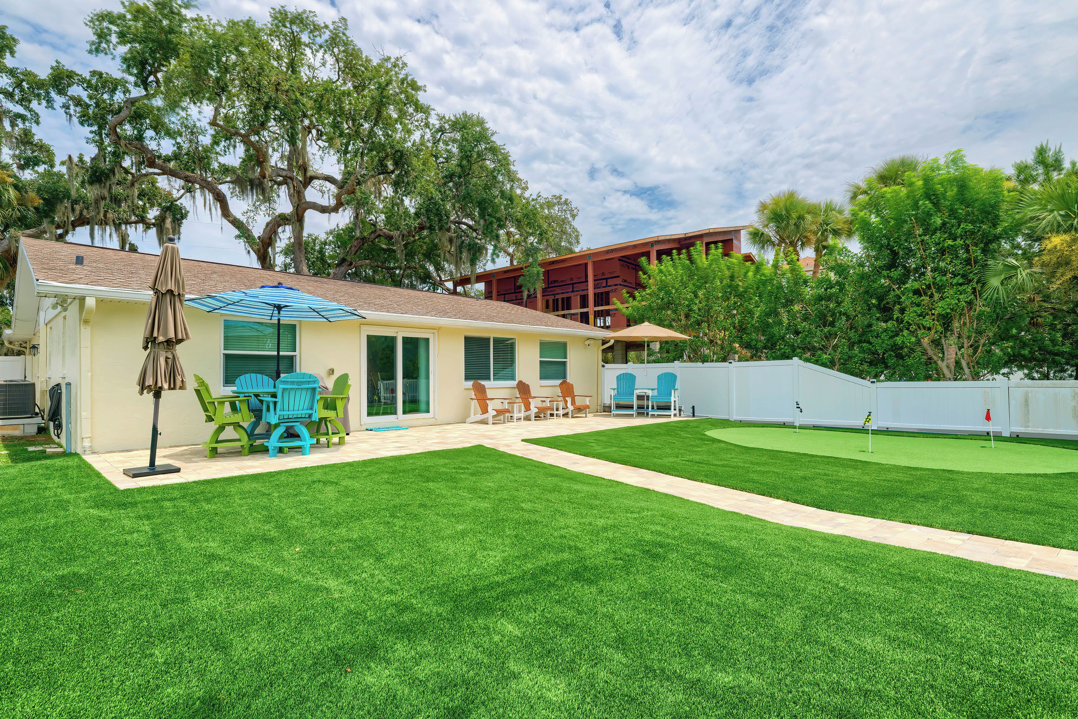 Una propiedad residencial con un patio, mobiliario exterior y un césped bien cuidado.
