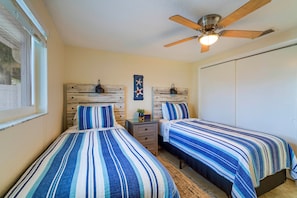 A bedroom with two beds, a ceiling fan, and a wardrobe. - Riverfront Home w/ Putting Green & Boat Dock! (New Port Richey)