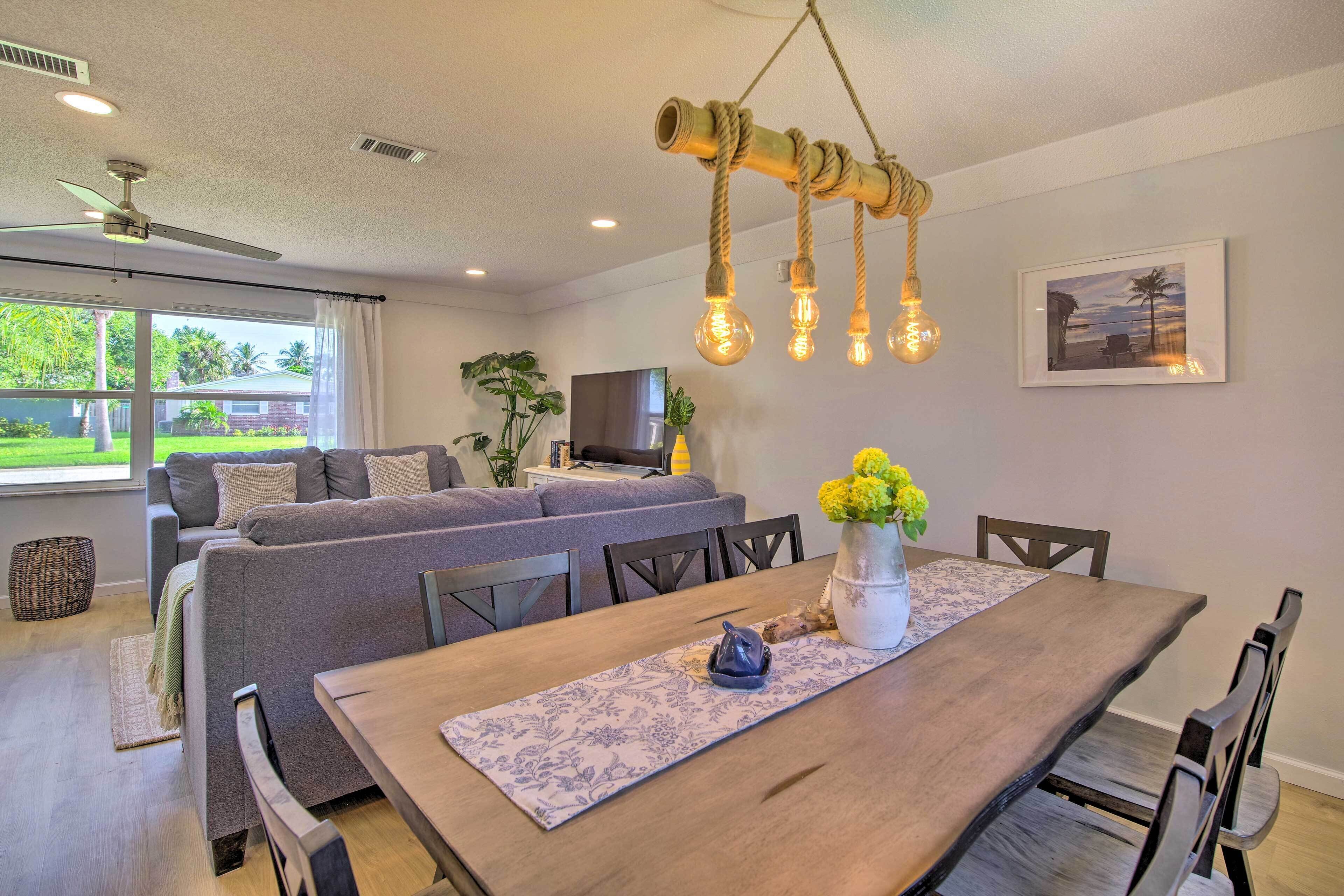A modern living room with a sofa set, dining table, and a TV.