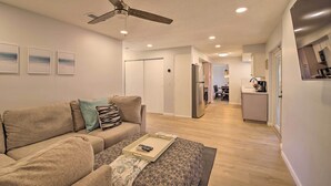A modern living room with a sofa, a coffee table, and a ceiling fan.