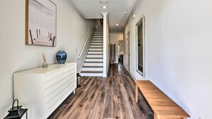 A hallway with a staircase, a white console table, and a bench. - Santa Rosa Beach Vacation Rental Near Ocean! (Santa Rosa Beach)
