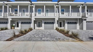 A modern multi-story residential building with a symmetrical facade, multiple balconies, and a paved driveway. - Santa Rosa Beach Vacation Rental Near Ocean! (Santa Rosa Beach)
