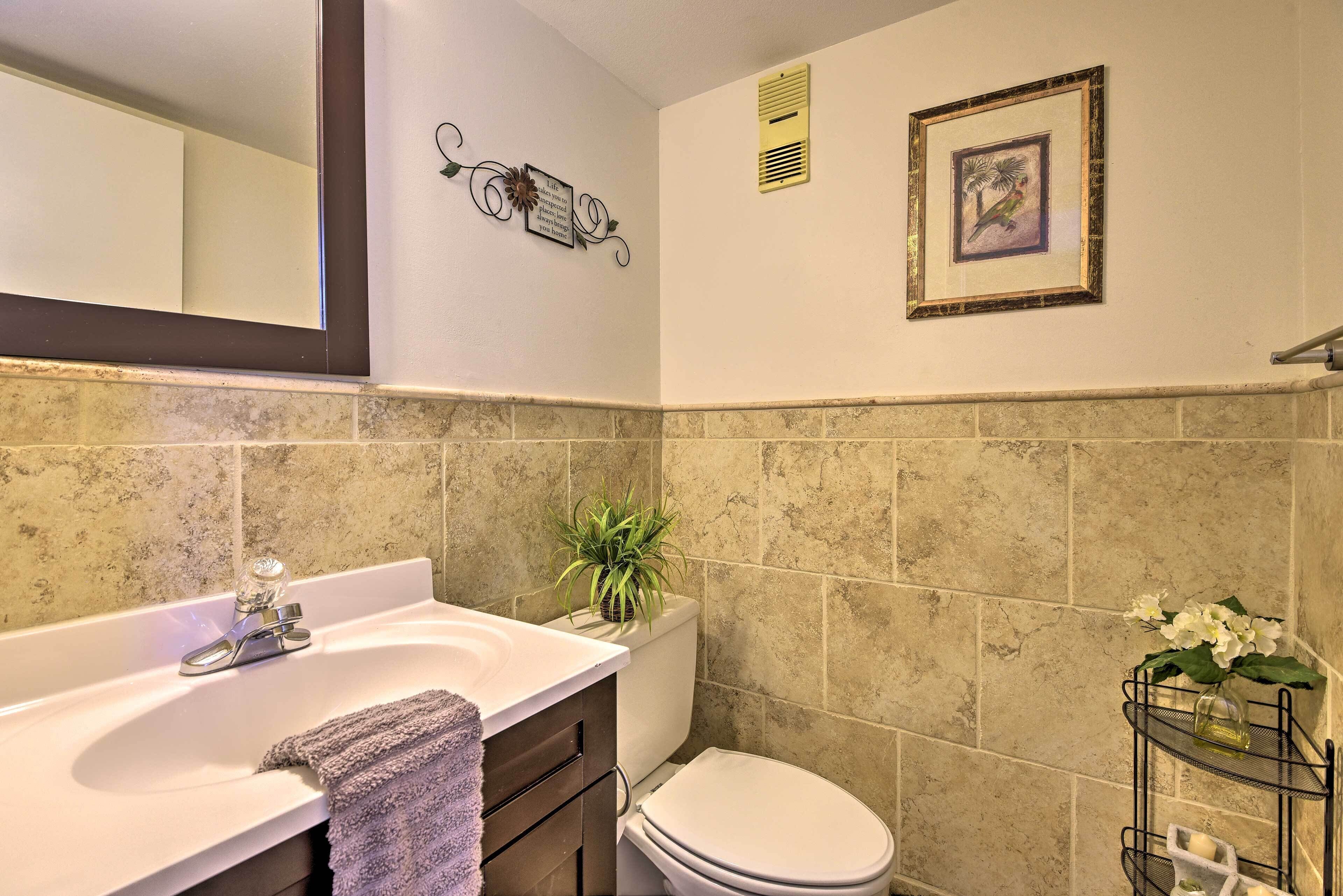 A bathroom with a white sink, a toilet, and a towel rack.