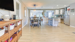 A modern kitchen with a dining area, wooden furniture, and a flat-screen TV. - Private & Picturesque Escape on Lake Henry! (Lake Placid)