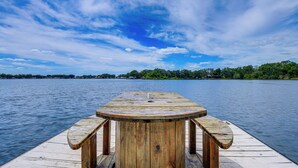 A wooden dock with a bench and a table, overlooking a calm lake with a distant shoreline. - Private & Picturesque Escape on Lake Henry! (Lake Placid)