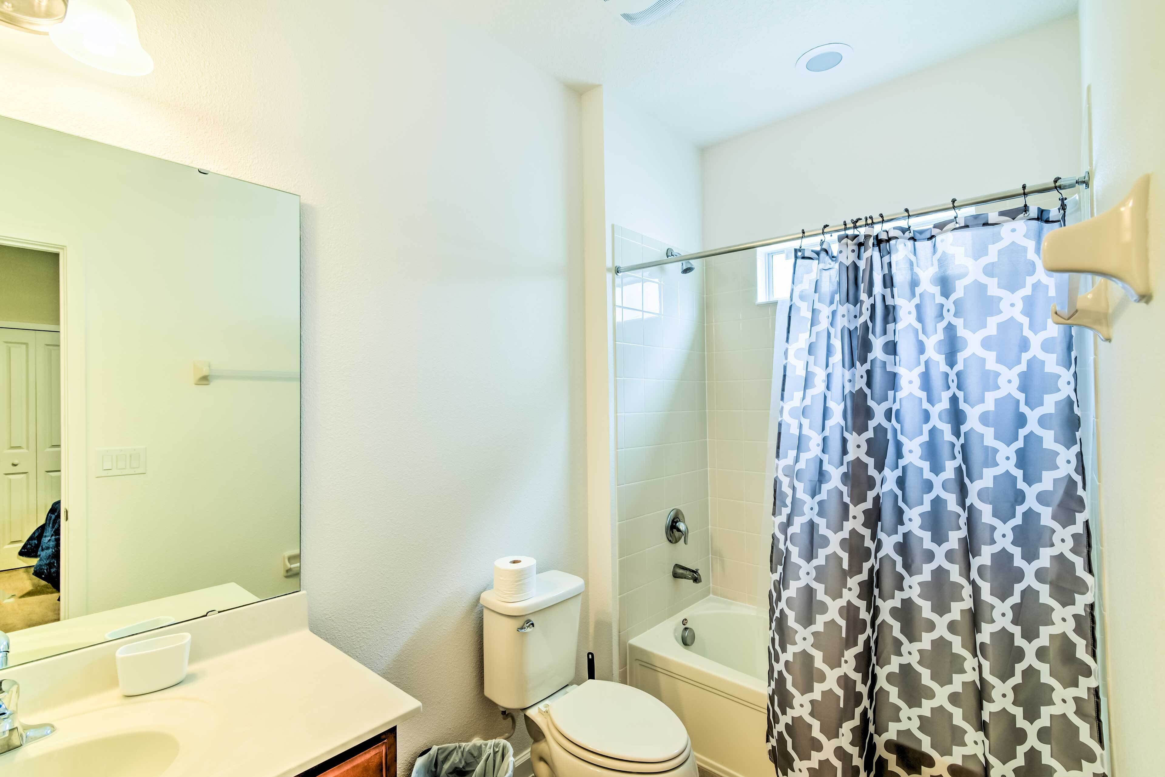 A bathroom with a toilet, sink, and shower curtain.