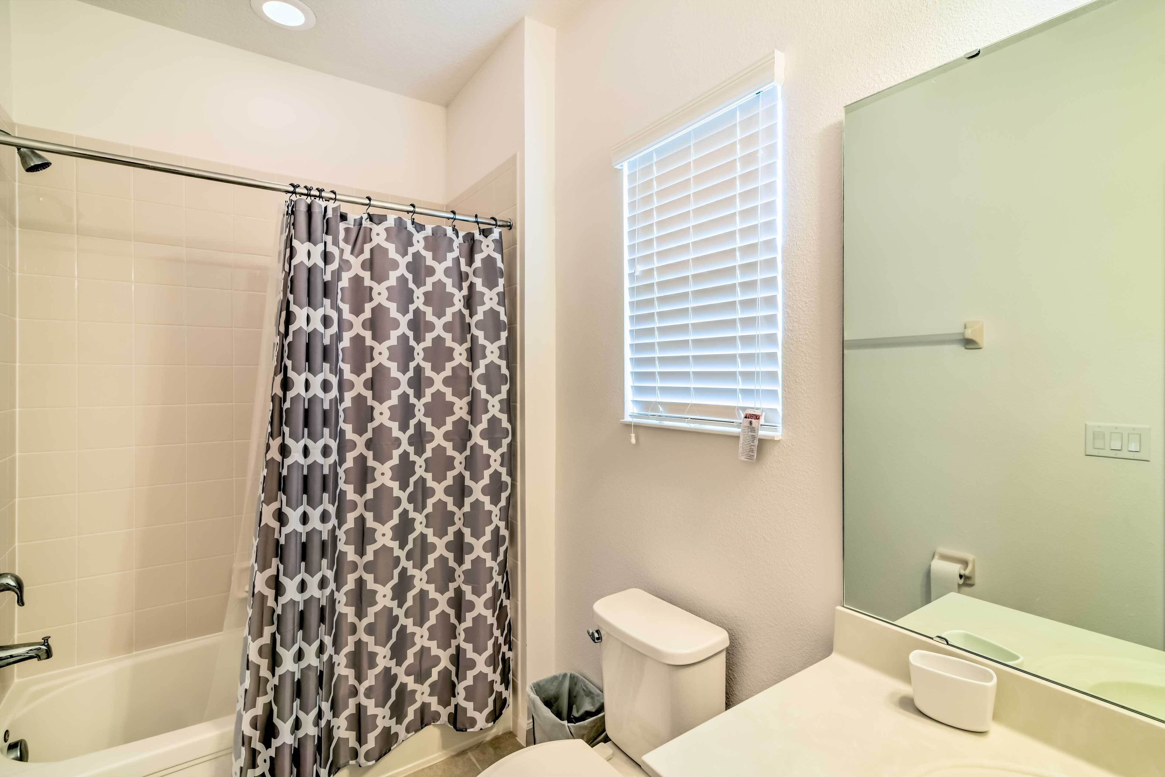Une salle de bain avec douche, toilettes et lavabo.