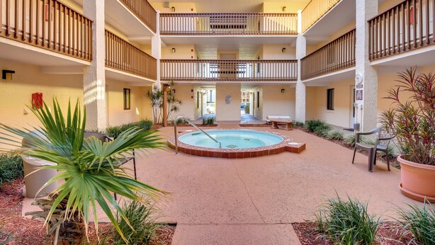 A courtyard with a central pool, multiple balconies, and outdoor seating areas. - St. Augustine Condo Near Flagler College & Beach! (St. Augustine)
