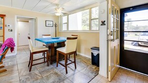A dining area with a table and chairs, a ceiling fan, a window with a view of the outside, and a door leading to the outside. - Sunny Florida Condo: 4 Mi to Gulf Islands Seashore (Fort Walton Beach)